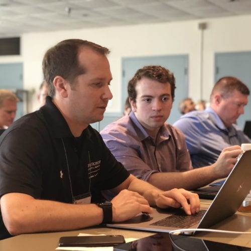 Picture of three men in a classroom training environment